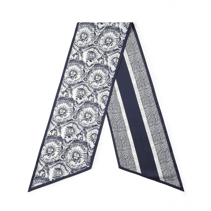 A 16 Momme SusanSilk Luxury Silk Twill Long Scarf named Gerbera, featuring an intricate blue and white floral pattern on one side and a combination of stripes and polka dots on the other.