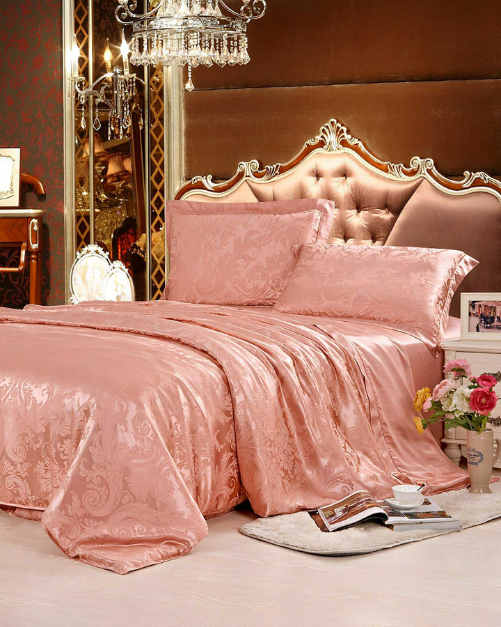 A luxurious bedroom with an ornate design features a king-sized bed adorned in the 19 Momme Jacquard Silk Bedding Set - 4Pcs from SusanSilk, complete with a tufted headboard and a chandelier overhead. Flowers, books, and a tea set are placed nearby.