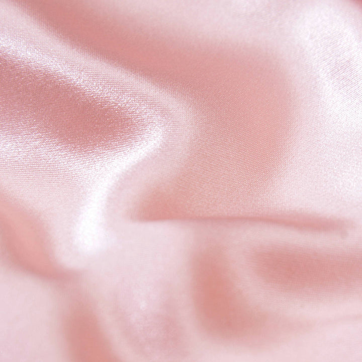 Close-up of a smooth, flowing Elegant Silk Eye Mask - Pink Canyon by SusanSilk, showcasing its soft pink fabric with a glossy surface.