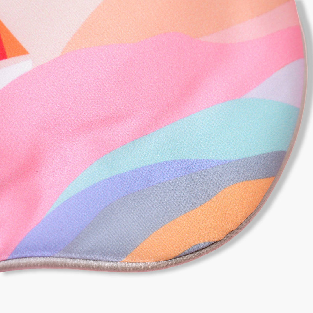 A close-up of the Elegant Silk Eye Mask by SusanSilk, showcasing its vibrant wave-like pattern in shades of pink, orange, blue, purple, and gray.