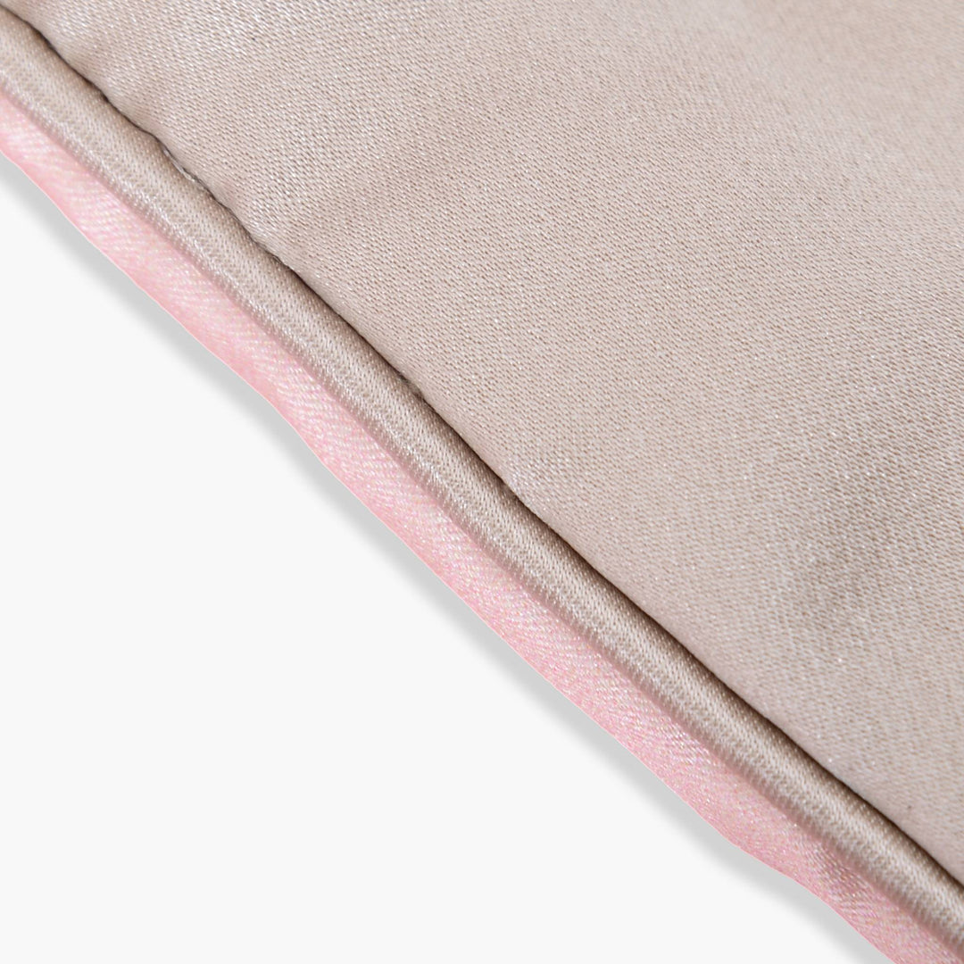 Close-up of a fabric seam on the SusanSilk Elegant Silk Eye Mask - Colorful Sailboat, showcasing a beige silk top layer and a pink bottom layer with a neatly stitched edge.