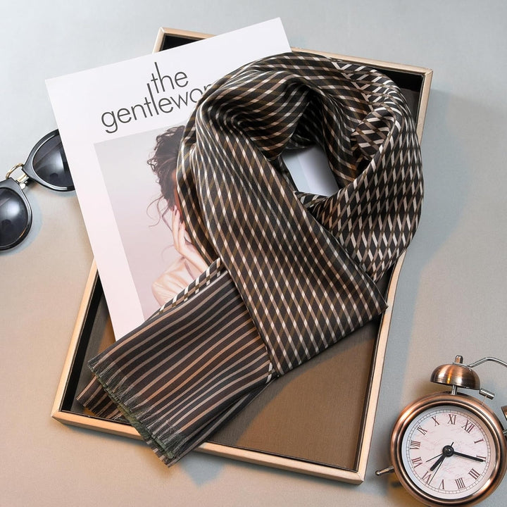 A Luxurious Men's Silk Twill Scarf in green by SusanSilk is neatly placed on top of a folded magazine beside sunglasses and a pocket watch.