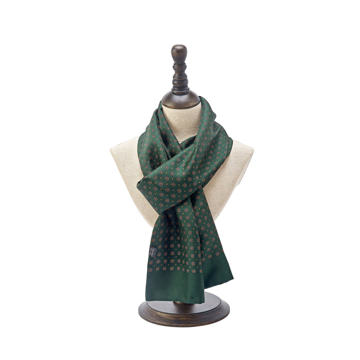 A SusanSilk Geometric Pattern Long Silk Scarf in green, elegantly displayed on a beige mannequin bust with a dark wooden base.