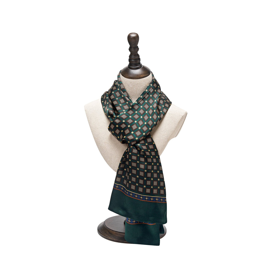 The Journey Grid Series Long Silk Scarf by SusanSilk, featuring a dark green pattern, is displayed on a mannequin bust with a wooden base against a white background.