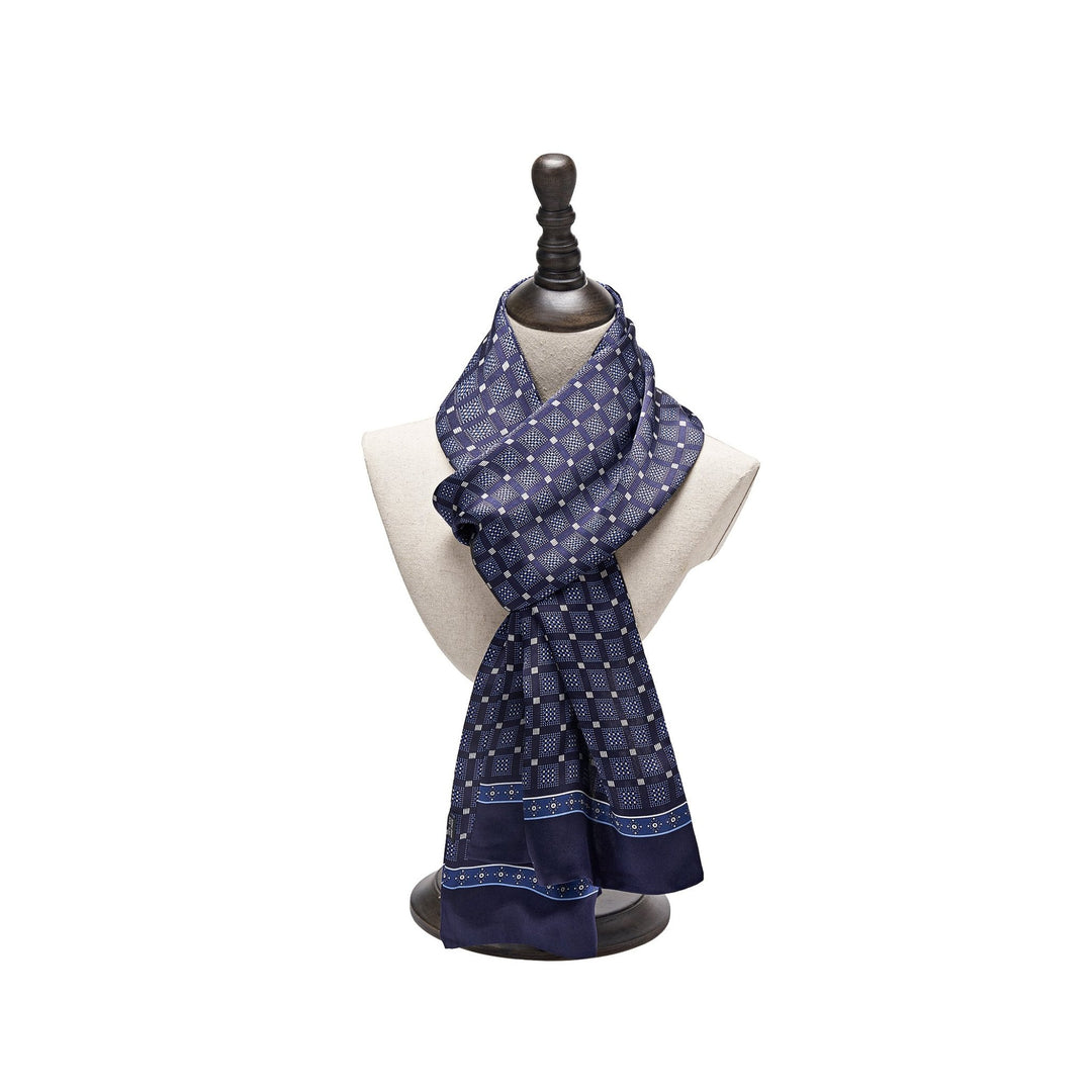 A Journey Grid Series Long Silk Scarf from SusanSilk in navy blue pattern is elegantly displayed on a black mannequin bust with a light-colored neck.