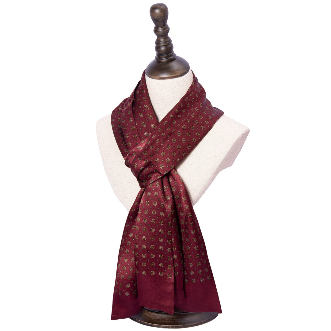 A Geometric Pattern Long Silk Scarf from SusanSilk in burgundy is draped around a mannequin bust on a wooden stand.