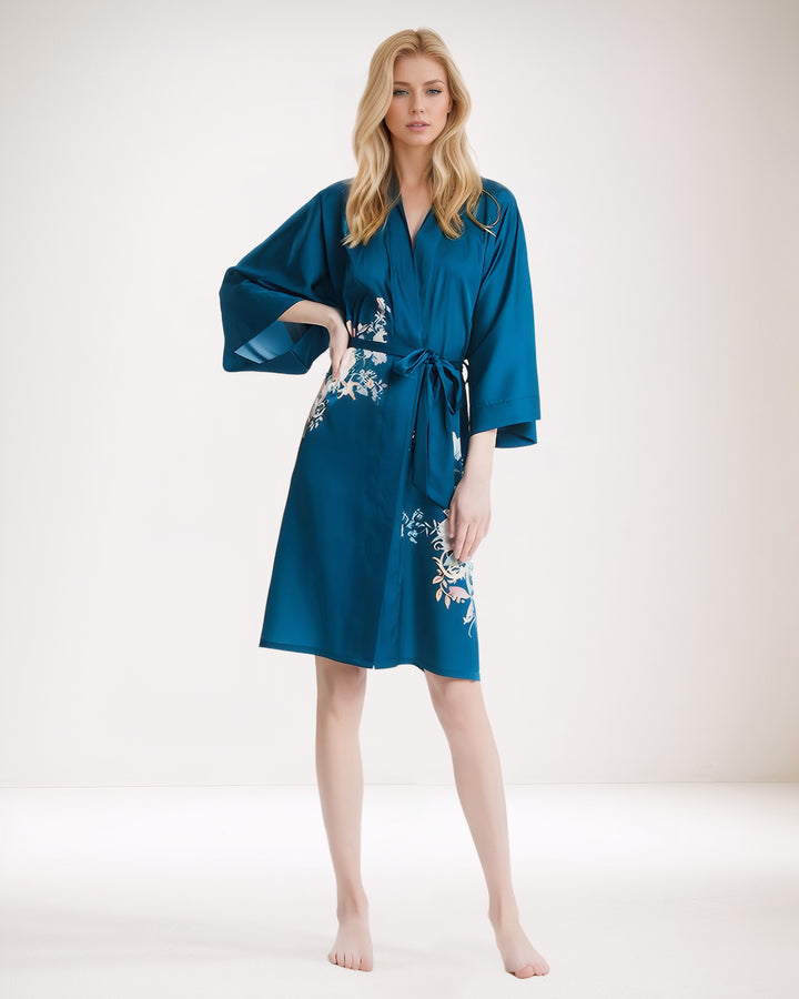 A person is standing barefoot, wearing the Peony Floral Short Silk Kimono from SusanSilk.