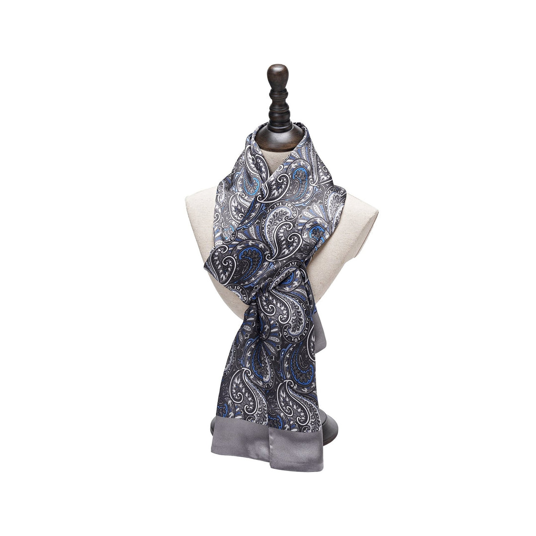 A Paisley Series Long Silk Scarf from SusanSilk, featuring an elegant paisley pattern in shades of grey and blue, beautifully displayed on a mannequin bust.