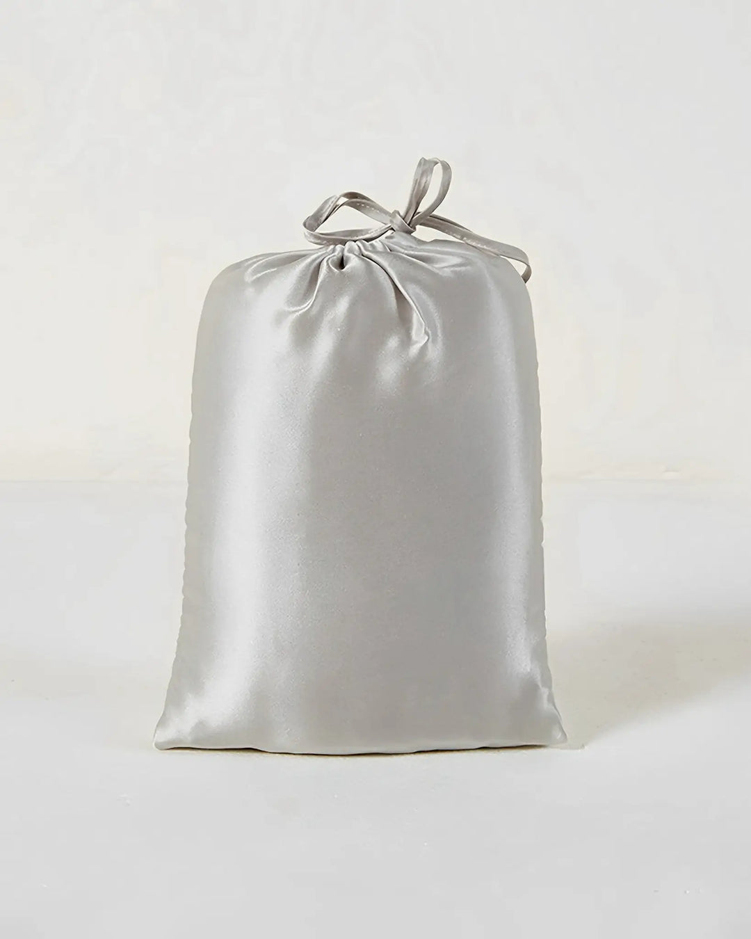 A 16 Momme Antibacterial Mulberry Silk Travel Sleep Sack by SusanSilk, reminiscent of luxurious silk, closes securely at the top and rests upright against a plain white background.