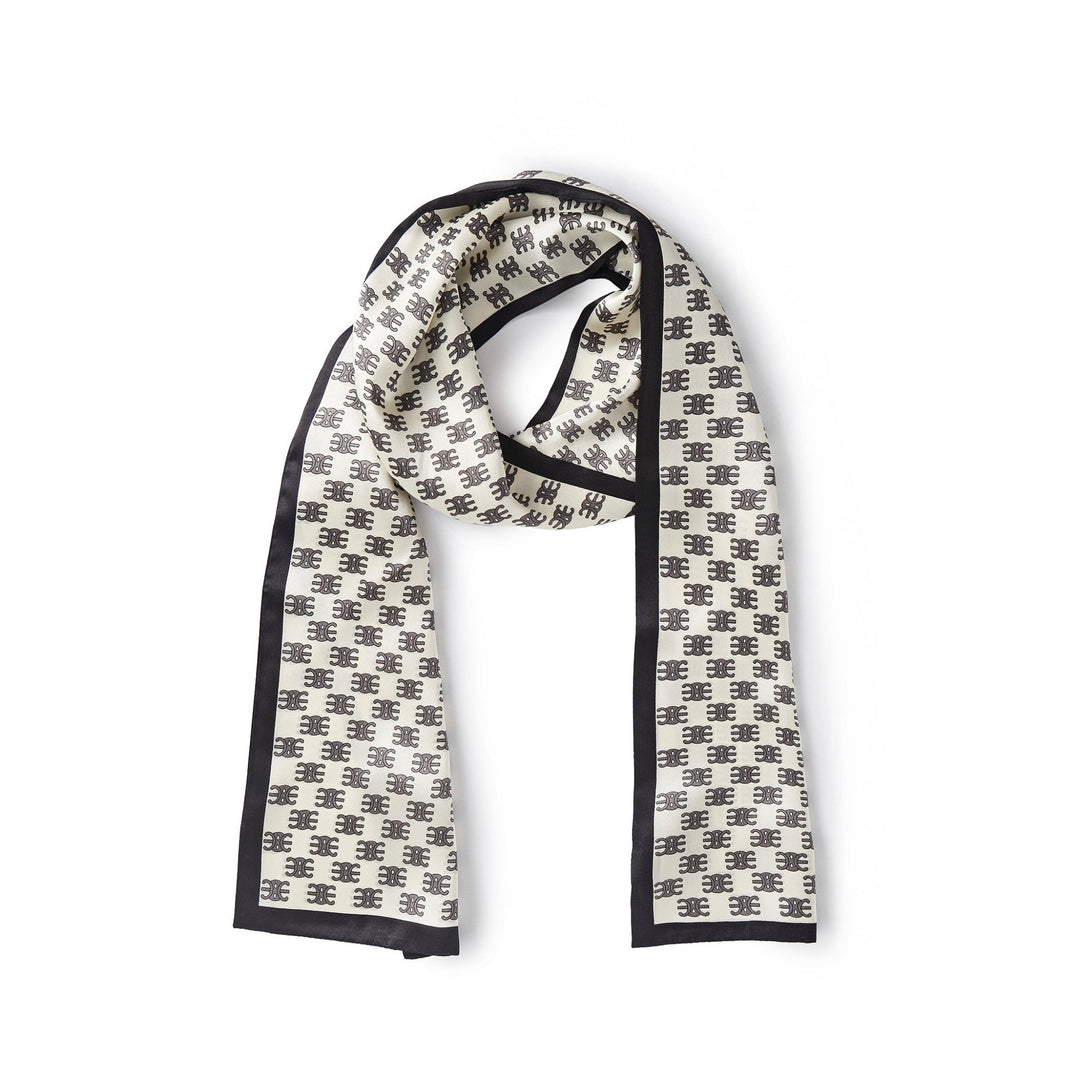 The Arc De Triomphe Narrow Long Silk Scarf by SusanSilk, featuring a luxurious white base with a black border and a repetitive black geometric pattern design, is laid flat on a plain white background.