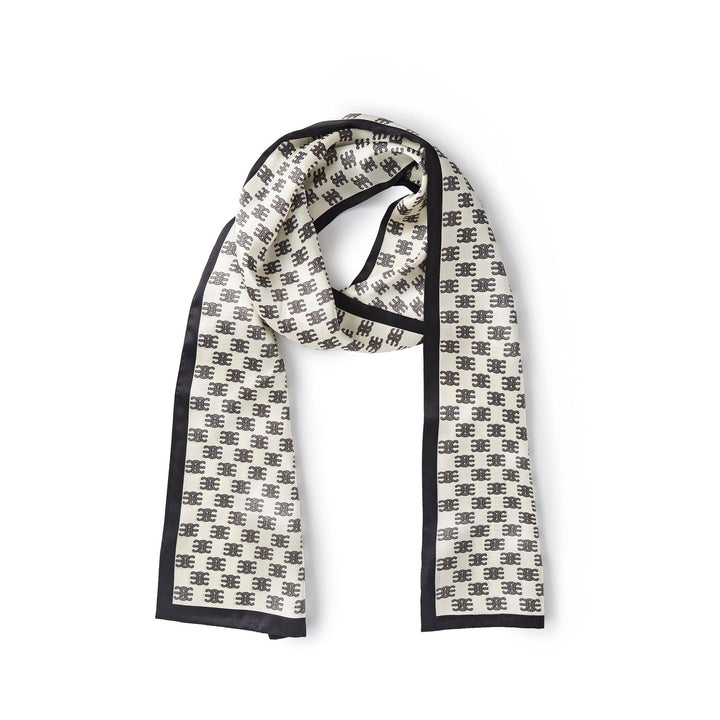 The Arc De Triomphe Narrow Long Silk Scarf by SusanSilk, featuring a luxurious white base with a black border and a repetitive black geometric pattern design, is laid flat on a plain white background.