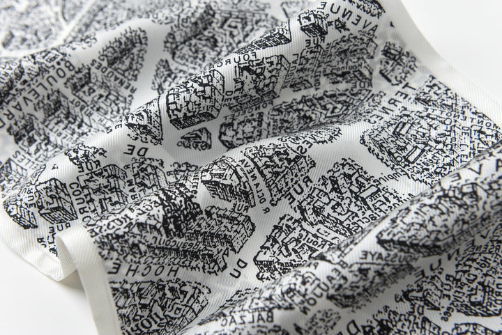 A close-up of the SusanSilk 16 Momme Affordable Luxury Silk Twill Long Silk Scarf-Black & White City, showcasing its intricate, black text-based map pattern that details streets, locations, and names in a dense, overlapping design on a white silk backdrop.