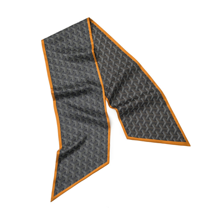 A long, rectangular scarf from the brand SusanSilk, made from luxurious 16 momme silk twill and featuring a dark geometric pattern with an orange trim, displayed laid out flat. The scarf is named ‘16 Momme Affordable Luxury Silk Twill Long Silk Scarf-Cubic Orange.’