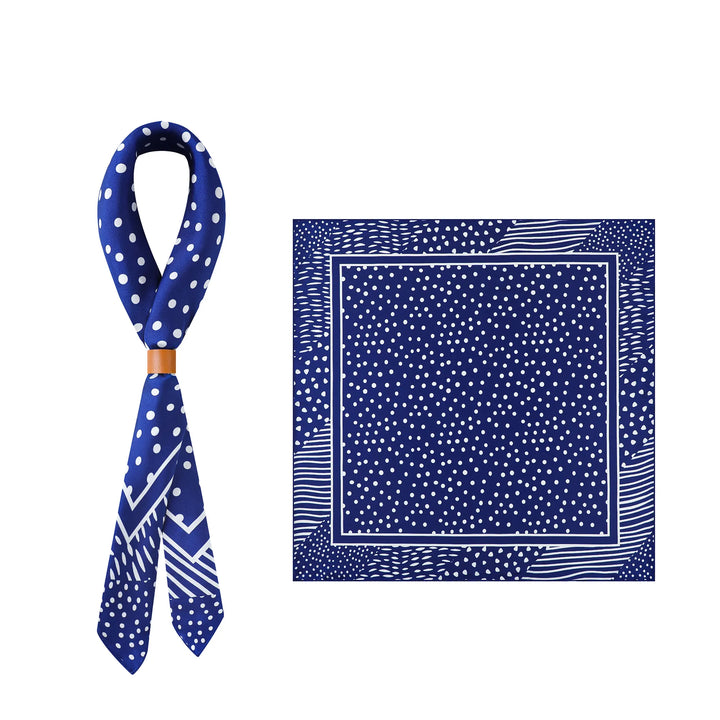 The Flourishing Star Square Silk Scarf by SusanSilk features a striking blue silk design with white polka dots and geometric patterns, showcased in two views: elegantly rolled with a beige ring, and laid flat. Discover the elegance of SusanSilk craftsmanship.