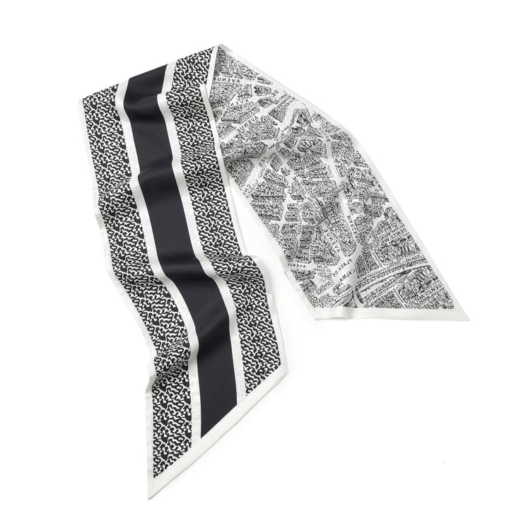 The 16 Momme Affordable Luxury Silk Twill Long Silk Scarf by SusanSilk, featuring black and white city map prints with bold stripes, lies flat on a white background.