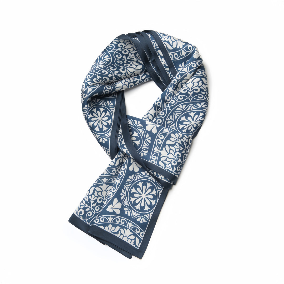 A folded Blue And White Silk Long Fluttering Belt with floral and geometric designs on a white background, crafted from SusanSilk for a touch of luxury.