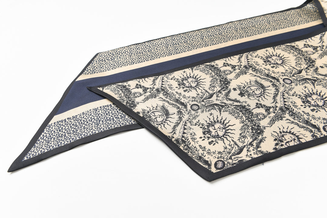 A 16 Momme Affordable Luxury Silk Twill Long Silk Scarf-Gerbera by SusanSilk, featuring intricate floral designs and bordered by solid navy and beige stripes, lies flat on a white surface.