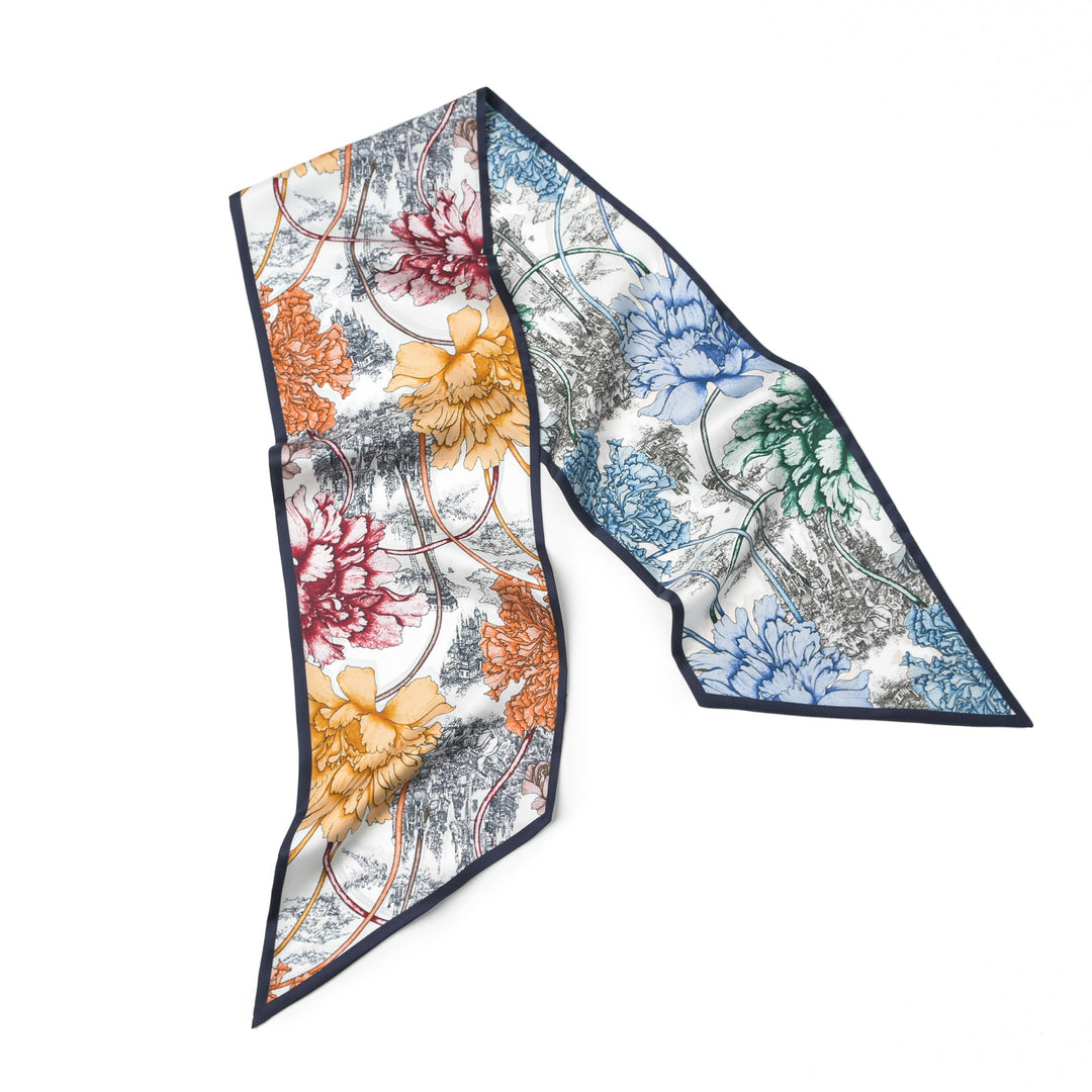 The 16 Momme Affordable Luxury Silk Twill Long Silk Scarf-Peony Mirage by SusanSilk showcases a floral print in vibrant orange, red, blue, and green sections with intricate black and white line drawings. The scarf features pointed ends and a sleek black trim.