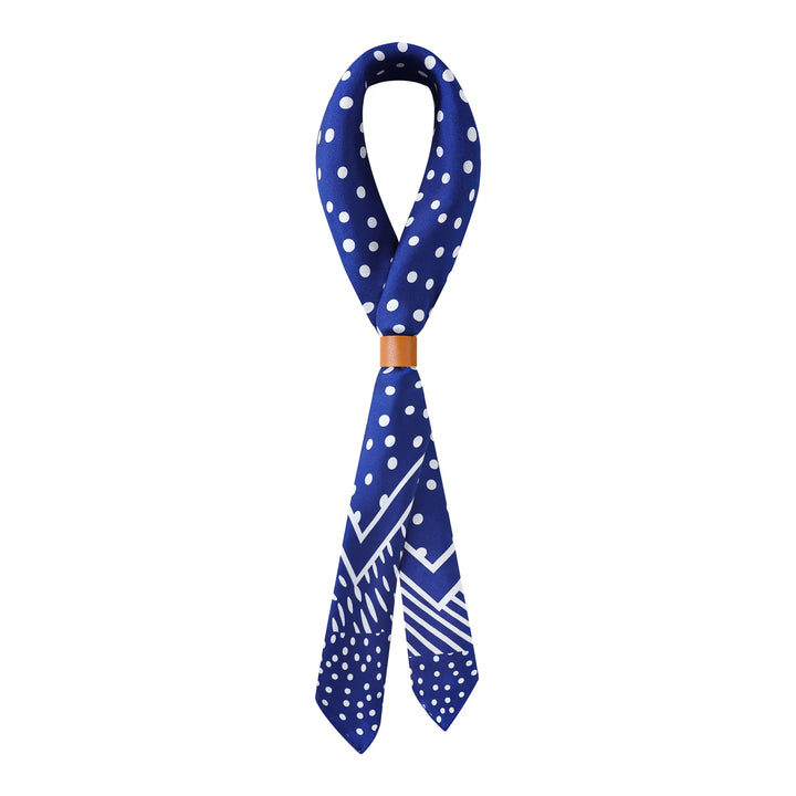 A Flourishing Star Square Silk Scarf from SusanSilk, featuring blue silk adorned with white polka dots and geometric patterns, knotted and displayed on a plain white background.