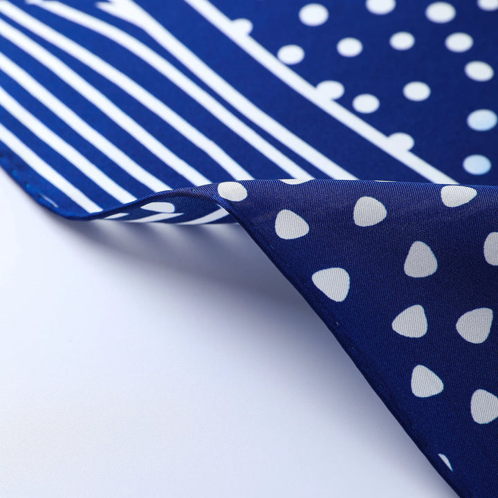 Close-up of the Flourishing Star Square Silk Scarf by SusanSilk, showcasing its blue silk fabric adorned with white polka dots and stripe patterns, highlighting the reversible design of this elegant cloth.