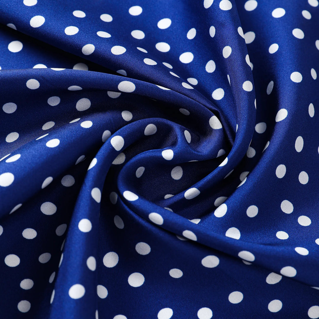 Close-up of the SusanSilk Flourishing Star Square Silk Scarf in blue with white polka dots, showing the material gathered in a swirl pattern.