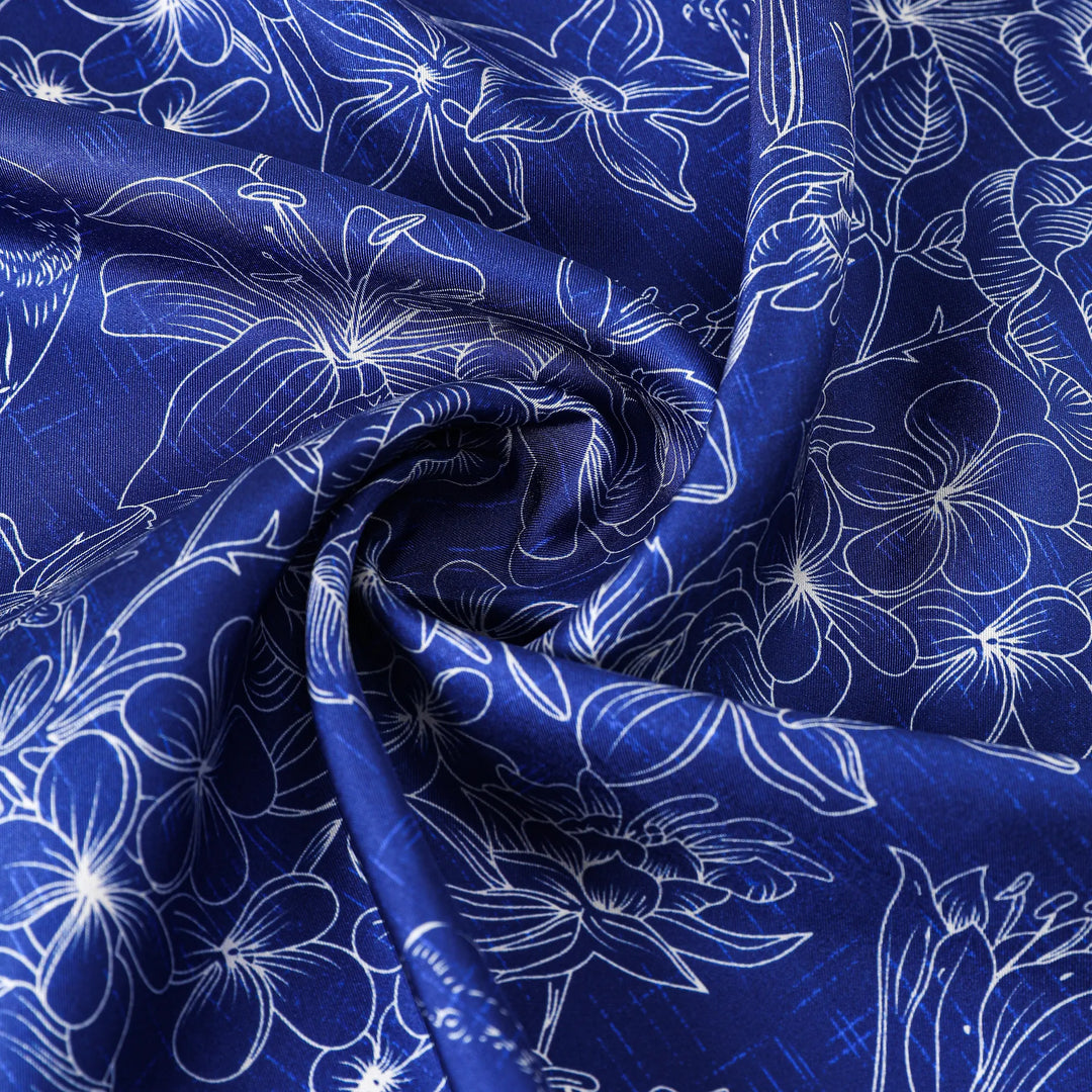 Close-up of the Deep Blue Square Silk Scarf by SusanSilk, showcasing intricate white floral patterns, elegantly twisted in the center.