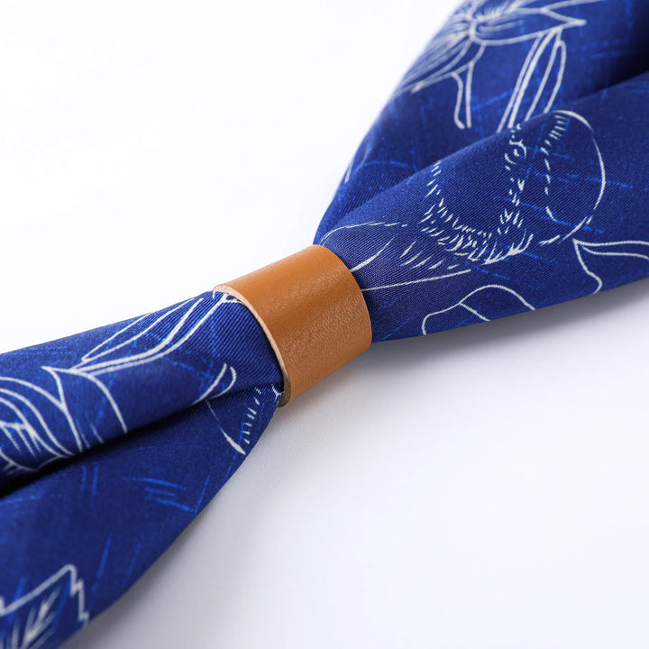 A Deep Blue Square Silk Scarf from SusanSilk featuring white line drawings of flowers and a central brown leather band.