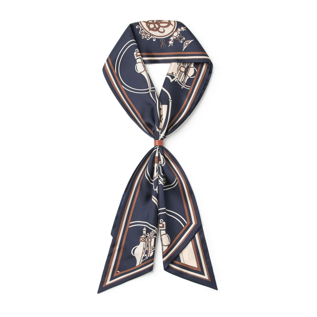 A luxurious SusanSilk 16 Momme Affordable Luxury Silk Twill Long Silk Scarf-Blue Striped Wagon with a nautical-themed print is knotted in the center. This silk design features navy blue, white, and brown colors with intricate ship and wheel details.