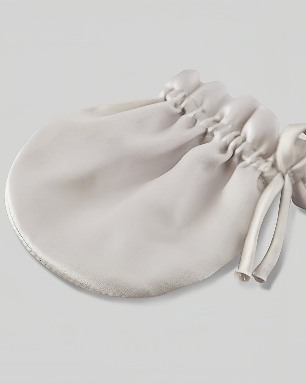 The SusanSilk 19 Momme Baby Silk Gloves Anti-Face Grabbing pouch lies flat against a plain background, showcasing the gathered opening and two drawstrings tied elegantly on one side.