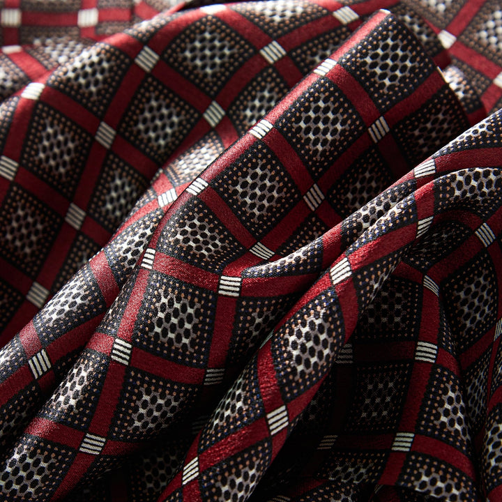 Close-up of the Journey Grid Series Long Silk Scarf by SusanSilk, featuring a red, black, and white checkered pattern with black dotted textures, displaying elegant folds and creases in the susansilk fabric.