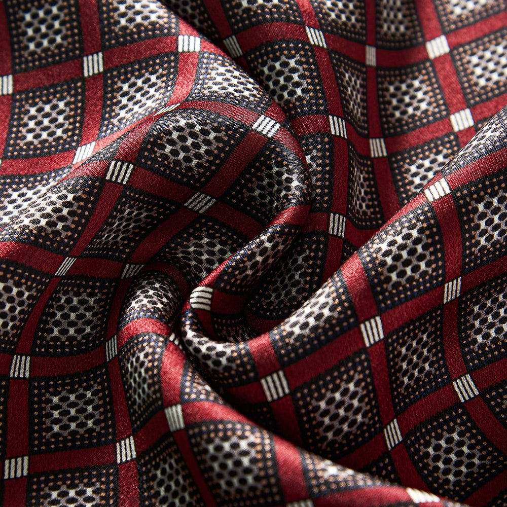 Close-up of the Journey Grid Series Long Silk Scarf by SusanSilk, showcasing a red and black checkered pattern with small white dots inside black squares and red borders. The silk material appears to be soft and slightly wrinkled.