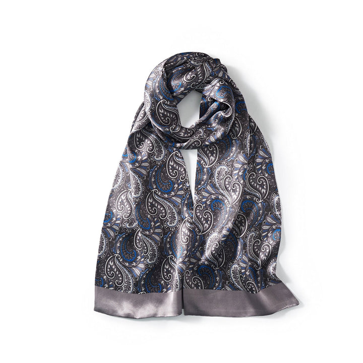 Introducing the Paisley Series Long Silk Scarf by SusanSilk, a luxurious accessory featuring a black background adorned with an elegant paisley pattern in shades of white and blue, complemented by a solid grey border at the ends.