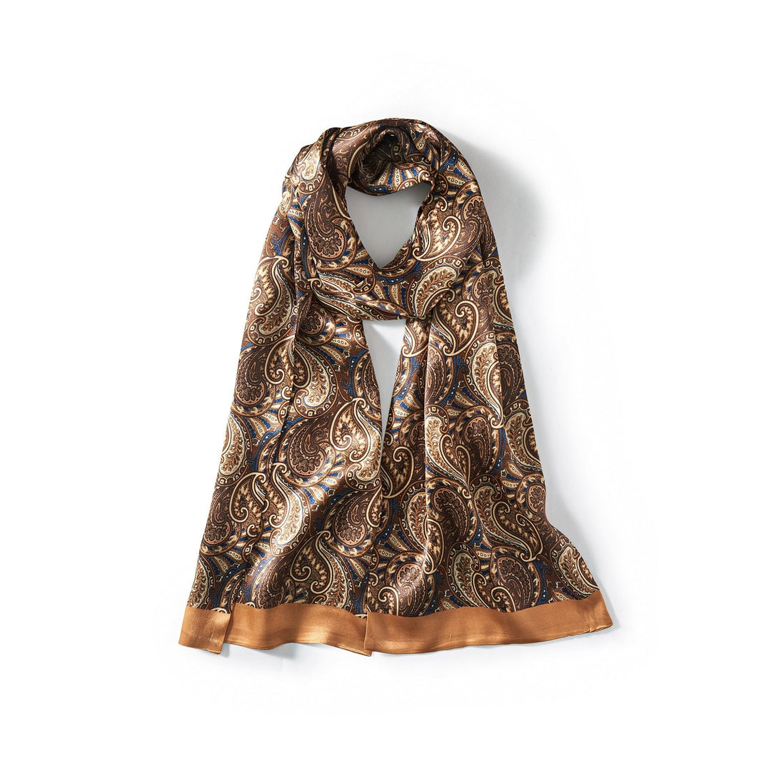 A Paisley Series Long Silk Scarf by SusanSilk, with a brown paisley pattern and a golden border, neatly tied in a simple knot and displayed against a plain white background.