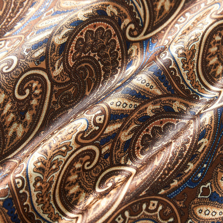 Close-up of the Paisley Series Long Silk Scarf by SusanSilk, featuring an intricate paisley pattern in shades of brown, beige, and blue, showcasing detailed swirling designs and smooth texture.