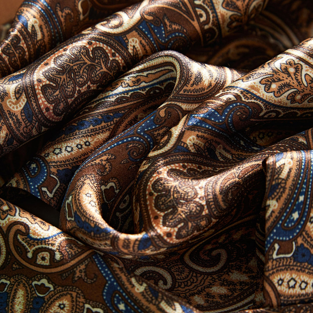 Close-up of the SusanSilk Paisley Series Long Silk Scarf featuring a detailed paisley pattern in shades of brown, blue, and beige.