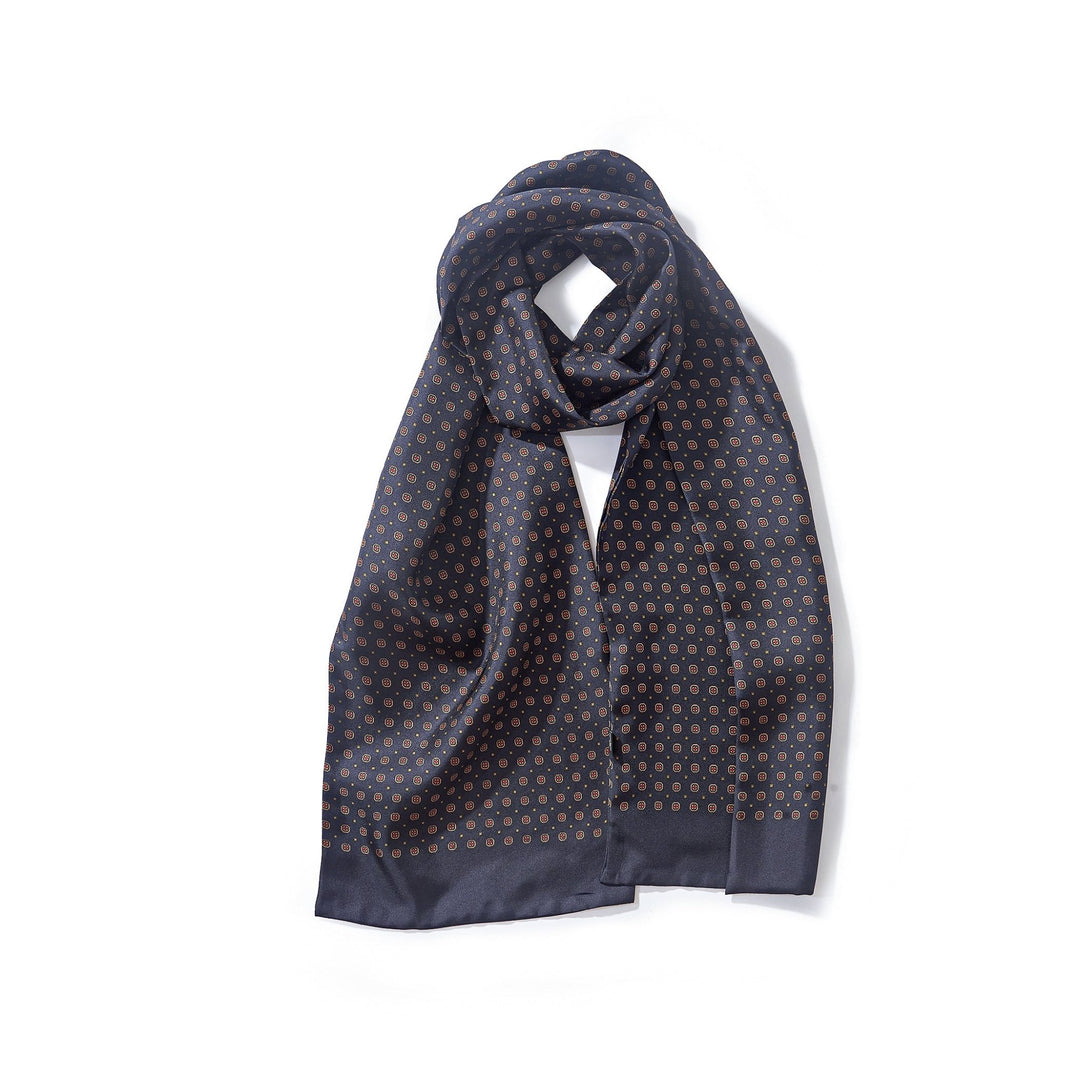 A Geometric Pattern Long Silk Scarf by SusanSilk in dark blue with a small brown geometric pattern, neatly folded on a plain white background.