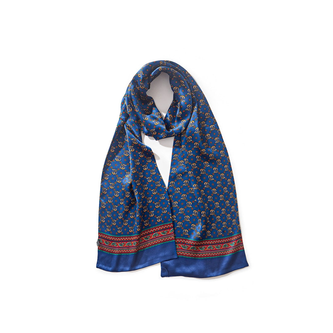 A SusanSilk Paisley Series long silk scarf in blue, featuring a small yellow and red geometric pattern and a red and blue decorative border at each end.