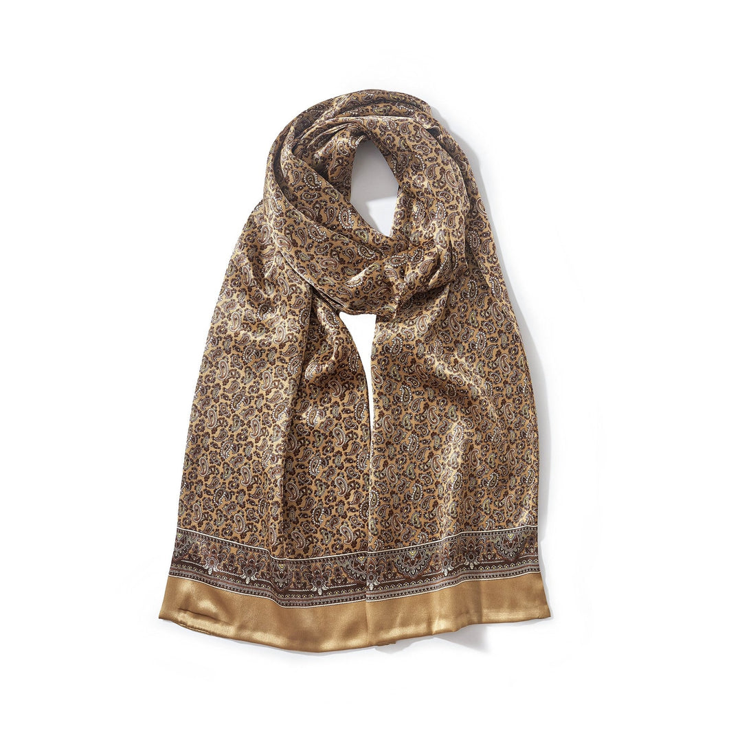 A Paisley Series Long Silk Scarf by SusanSilk in gold and brown, featuring intricate patterns and edges finished with a solid gold border, draped in a loop.