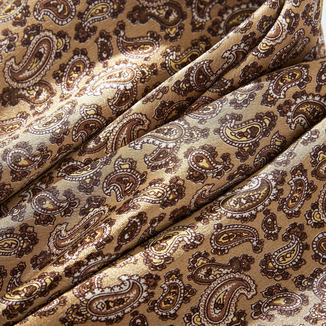 Close-up of the luxurious SusanSilk Paisley Series Long Silk Scarf, showcasing an intricate paisley pattern adorned with rich brown and gold hues.