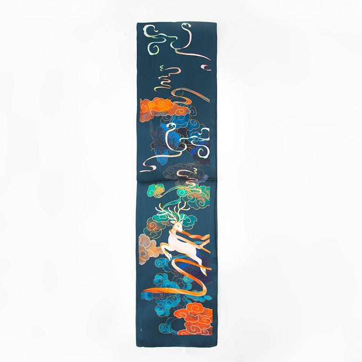 The Fairy Deer Long Mulberry Silk Scarf by SusanSilk features a long, dark green design adorned with colorful, abstract patterns including swirling motifs and a depiction of a figure riding a white horse surrounded by clouds.