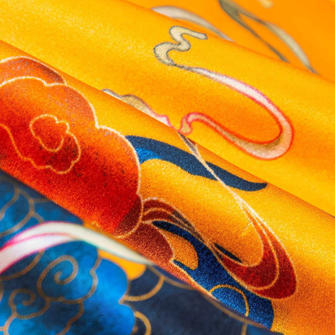 Close-up of the Fairy Deer Long Mulberry Silk Scarf by SusanSilk, showcasing its vibrant silk fabric adorned with intricate designs in orange, red, blue, and gold patterns.