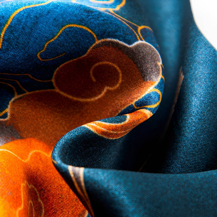 Close-up of the luxurious Fairy Deer Long Mulberry Silk Scarf by SusanSilk, showcasing its rich blue and orange colors with a swirling, cloud-like pattern.