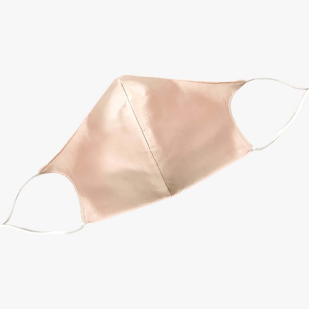 The SusanSilk Double Layer Silk Face Mask with Nose Wire, in a light pink color with white ear loops, is showcased against a white background.