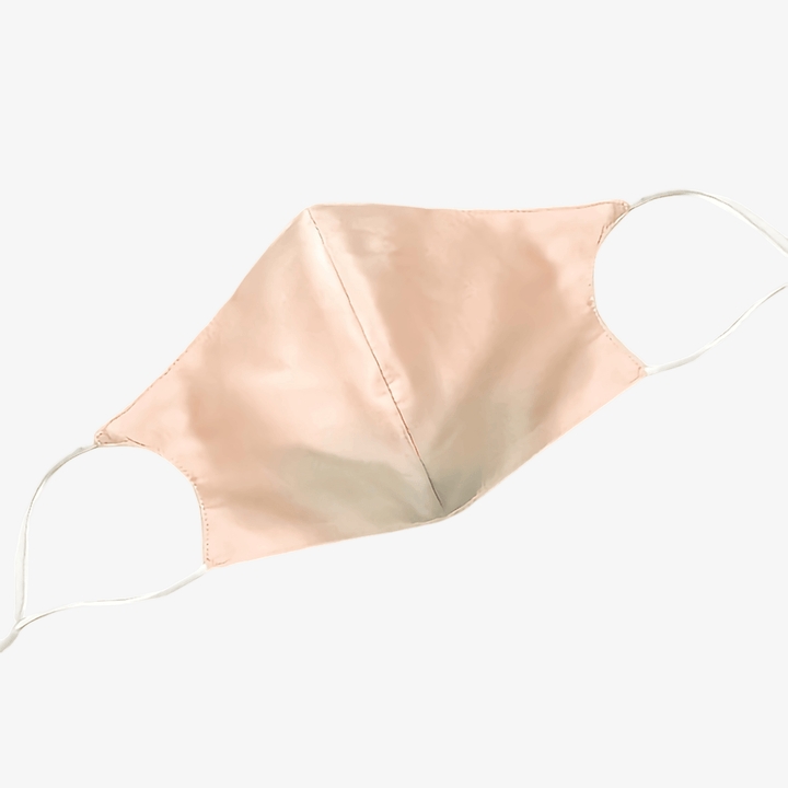 A light pink Double Layer Silk Face Mask with Nose Wire by SusanSilk, featuring white ear loops, displayed on a white background.