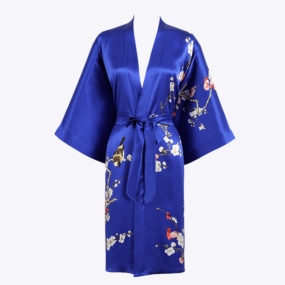 The Plum Blossom Short Silk Kimono by SusanSilk is a blue silk robe adorned with floral and bird embroidery, featuring wide sleeves and a matching waist tie.