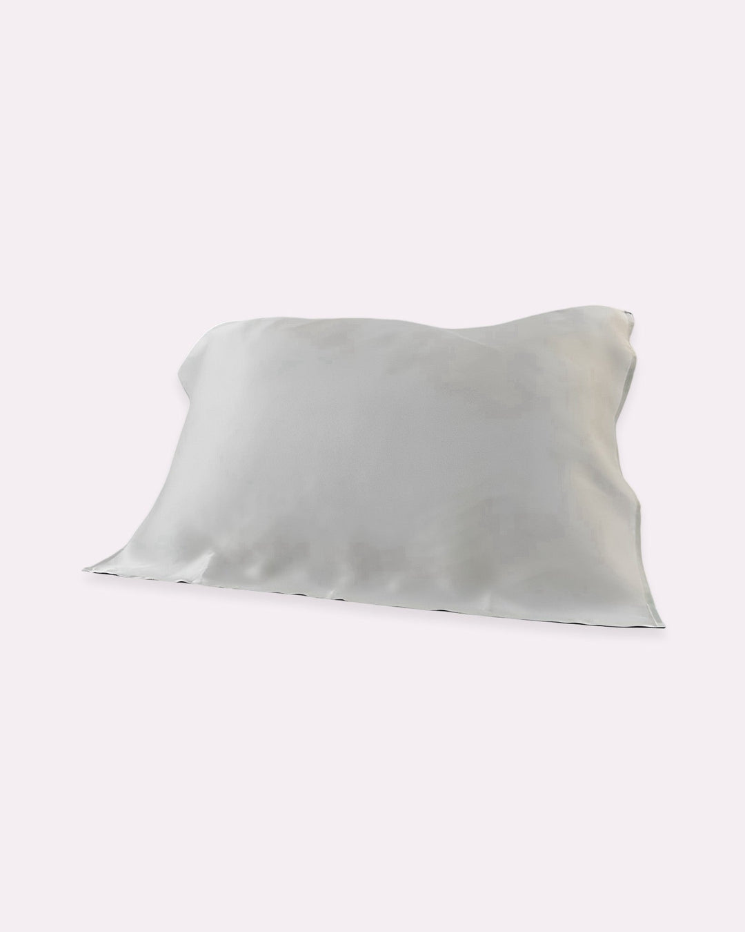 A silvery grey pillow with a smooth surface and slightly wrinkled edges, made of 100% silk, from the brand SusanSilk's 19 Momme Baby & Toddler Silk Pillow Cover collection, placed on a plain background.