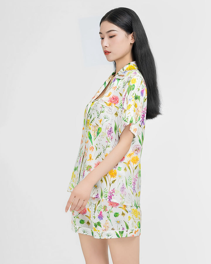 A person wearing the SusanSilk Floral Short Silk Pajamas Set stands against a plain background, looking to the side.