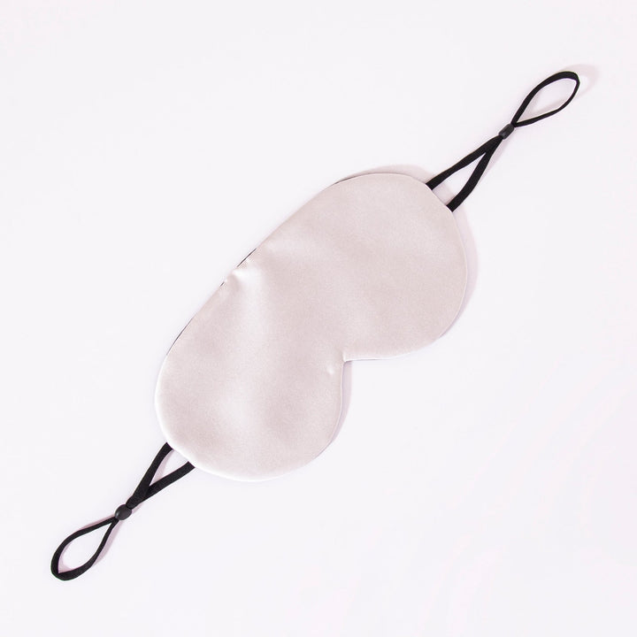 An Earth Tones Double Side Silk Eye Mask by SusanSilk, featuring black elastic straps, is laid flat on a white background.