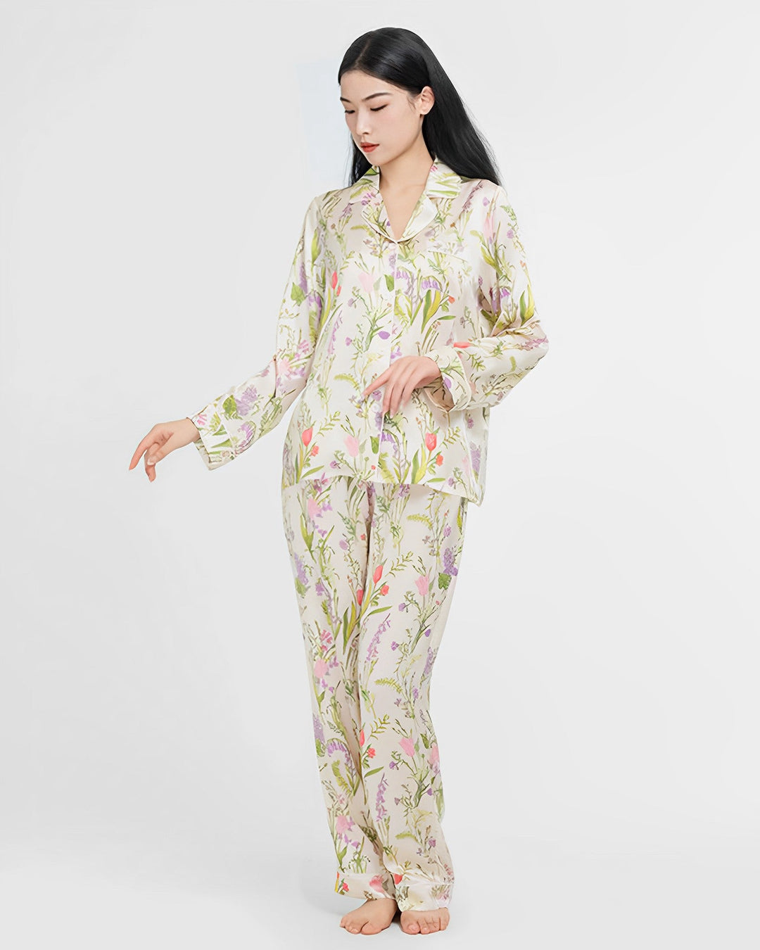 A woman wearing a 19 Momme Floral Silk Pajamas Set from SusanSilk stands barefoot against a white background.