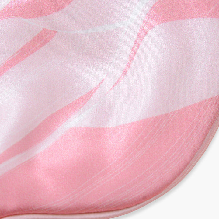 Close-up image of an Elegant Silk Eye Mask - Pink Canyon by SusanSilk, showcasing its pink and white wavy pattern.